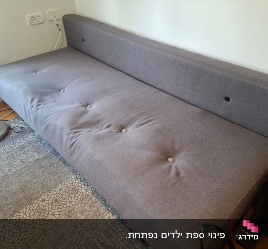 ספה אפורה עם כפתורים על שטיח מעוצב